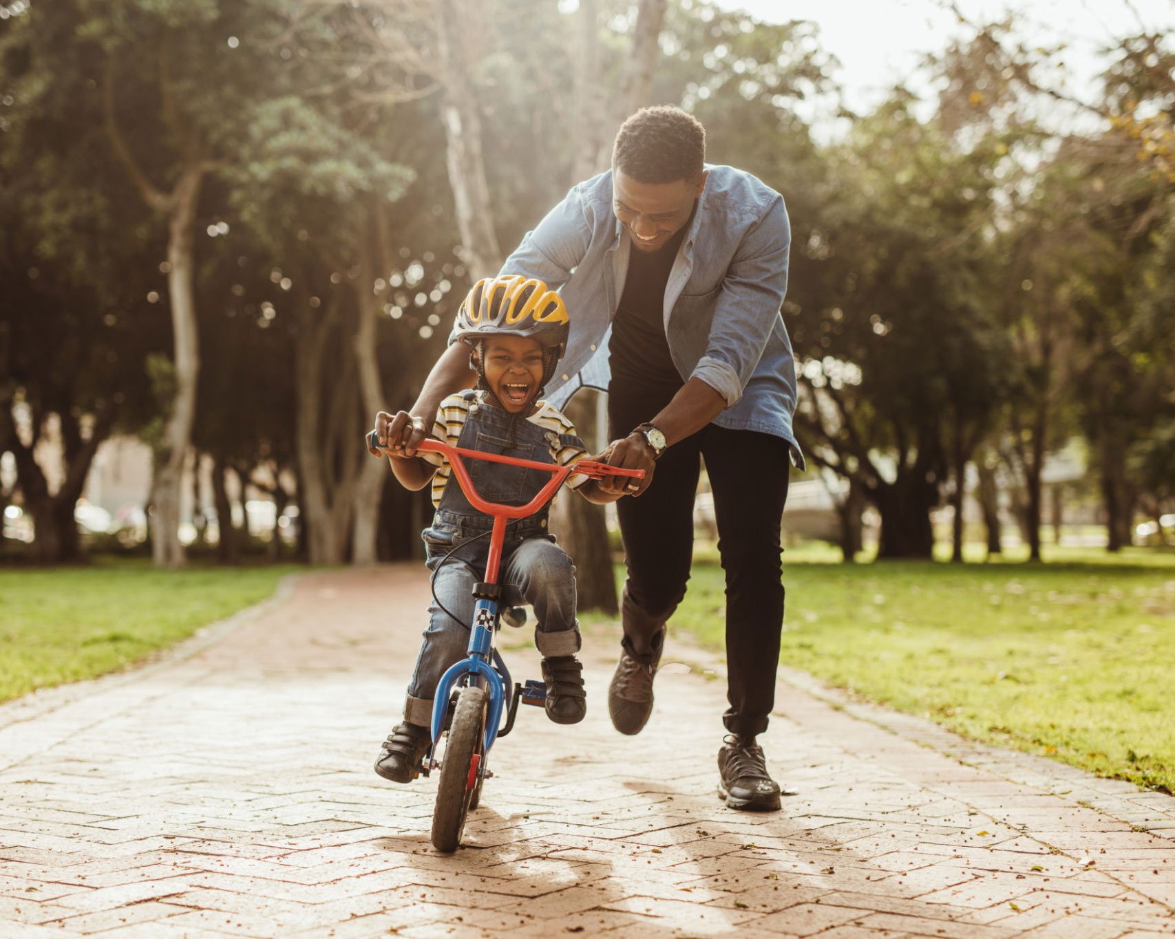 Dad teaching son to ride bicycle