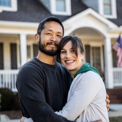 Couple standing in front of their new home